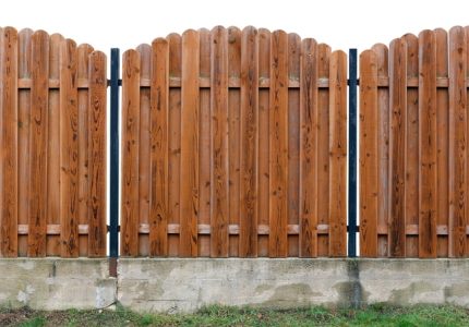 Long old yellow solid wooden rural fence from vertical planks