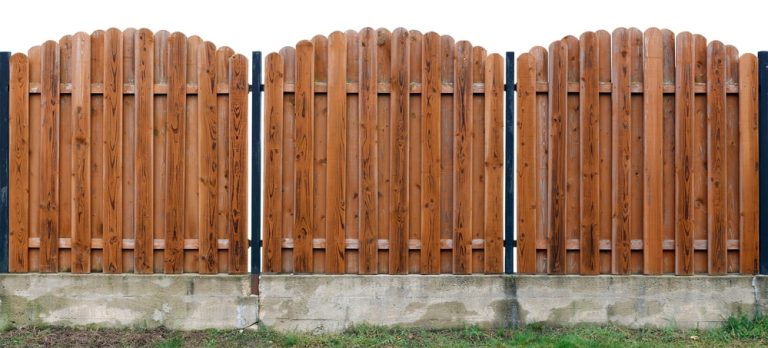 Long old yellow solid wooden rural fence from vertical planks
