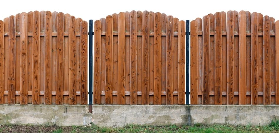 Long old yellow solid wooden rural fence from vertical planks